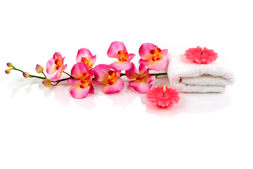 Pink orchids, a folded towel, and candles
